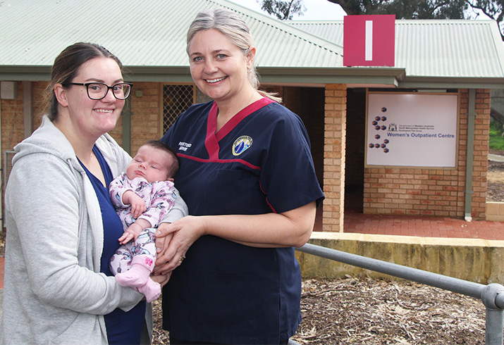 Claire McPherson holding baby Eloise with midwife Zoe.