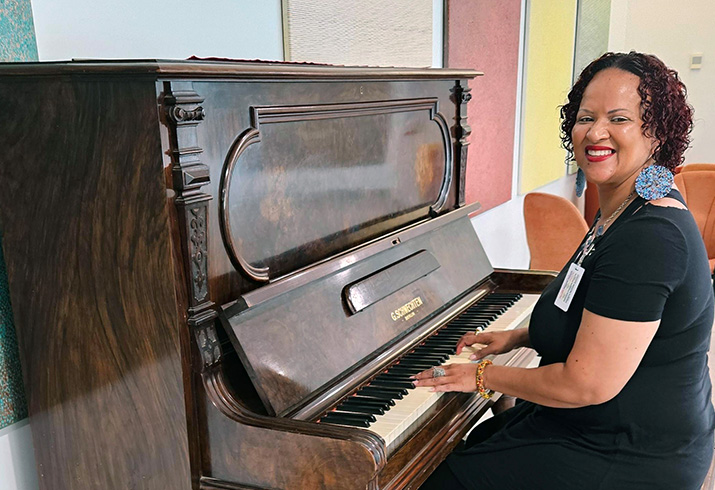 A woman sits playing a piano